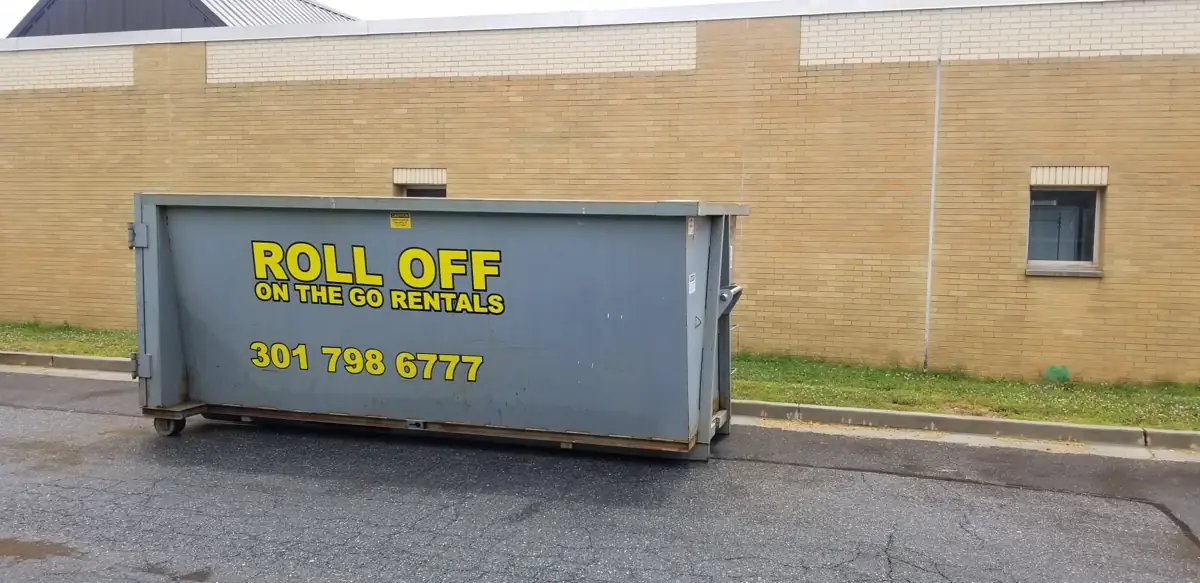 Roll Off On The Go container parked beside a brick building in Bethesda, MD