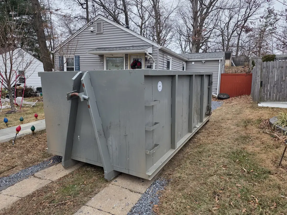 Roll off container set beside the front walkway of a small house in Rockville, MD